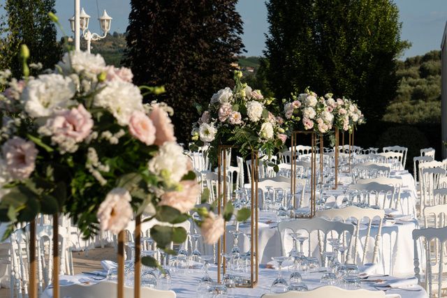Tavoli allestiti in giardino con composizioni floreali