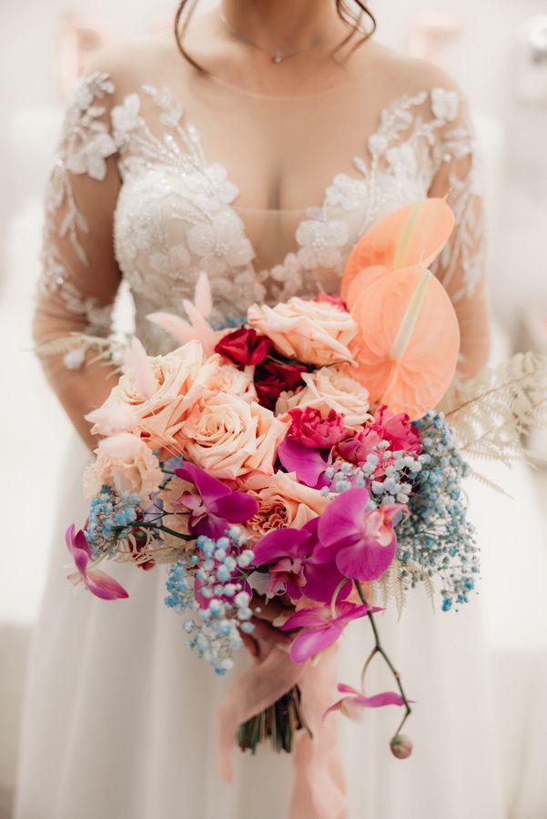 Sposa con bouquet di rose e orchidee