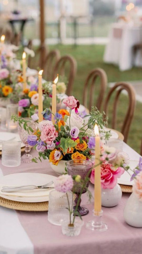 Tavola con fiori colorati e candele in giardino